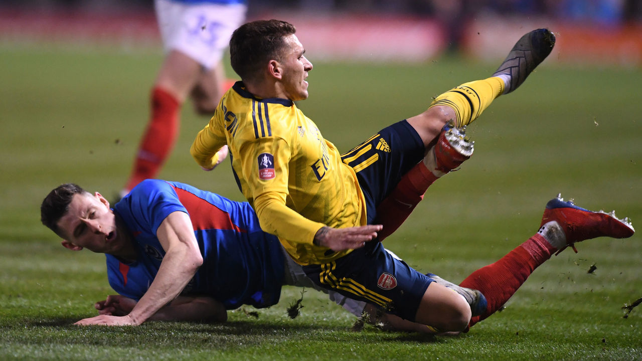 PORTSMOUTH, ENGLAND - MARCH 02: Lucas Torriera of Arsenal is tackled by James Bolton of Portsmouth during the FA Cup Fifth Round match between Portsmouth and Arsenal at Fratton Park on March 02, 2020 in Portsmouth, England.