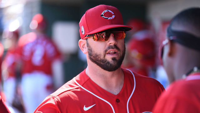 GOODYEAR, ARIZONA - FEBRUARY 24: Mike Moustakas #9 of the Cincinnati Reds prepares for a game with teammates during a spring training game against the Texas Rangers at Goodyear Ballpark on February 24, 2020 in Goodyear, Arizona.