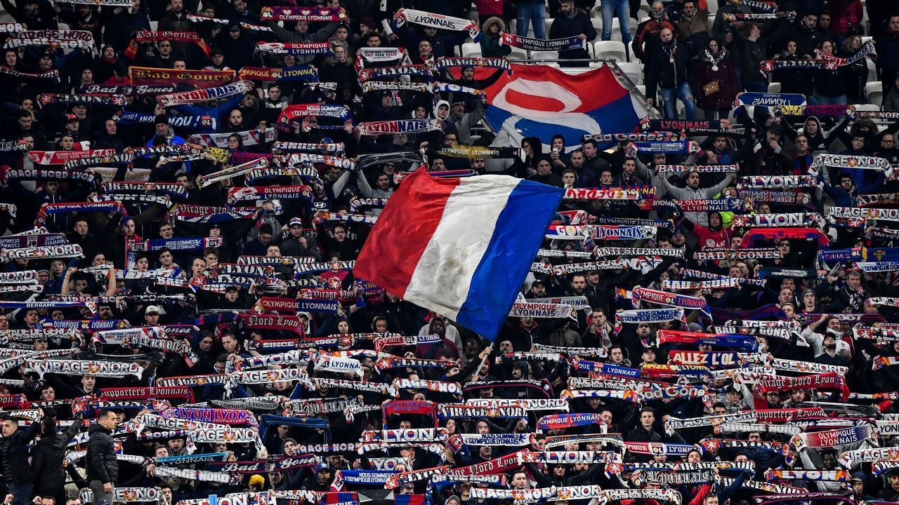 Lyon's supporters wave flags and hold banners during the French Cup semi-final football match between Olympique Lyonnais (OL) and Paris Saint-Germain (PSG) at the Groupama Stadium in Decines-Charpieu, centraleastern France, on March 4, 2020.