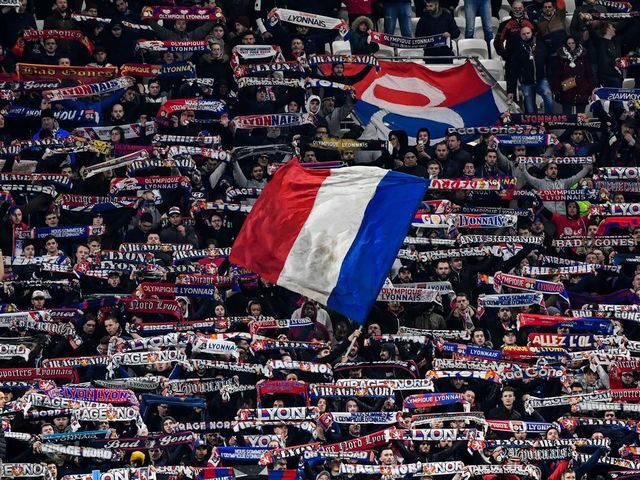Lyon's supporters wave flags and hold banners during the French Cup semi-final football match between Olympique Lyonnais (OL) and Paris Saint-Germain (PSG) at the Groupama Stadium in Decines-Charpieu, centraleastern France, on March 4, 2020.