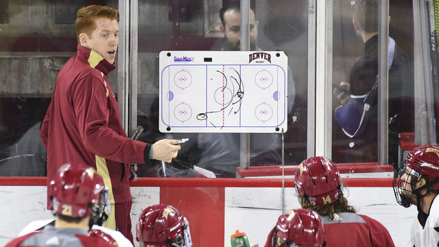 DENVER CO - APRIL 9: University of Denver's head hockey coach David Carle, at Magness Arena, talks to his players during practice before the team heads to the Frozen Four on April 9, 2019 in Denver, Colorado.