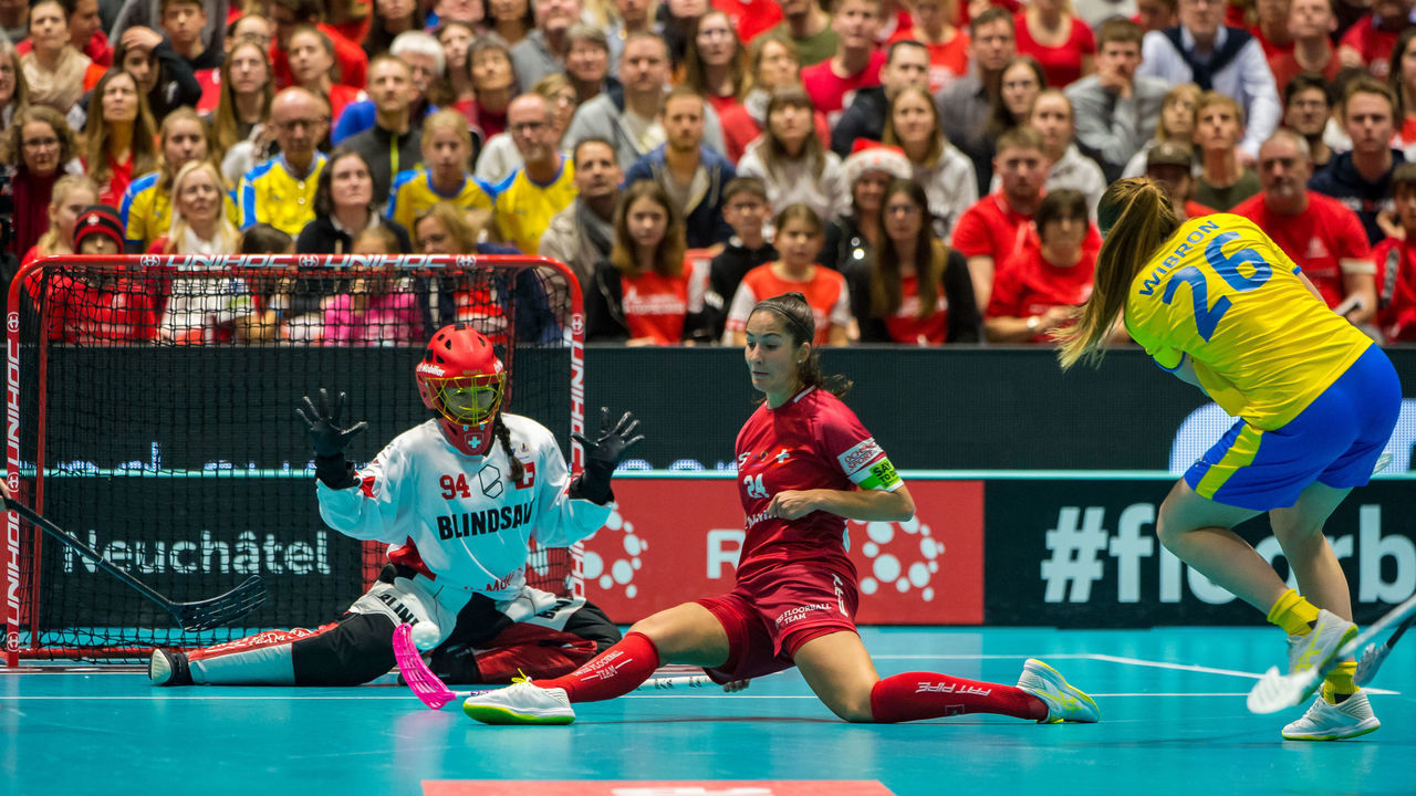 NEUCHATEL, SWITZERLAND - DECEMBER 15: #26 Wibron Emelie of Sweden tries to score against #24 Marti Flurina and #94 Heini Lara of Switzerland during the Gold Medal game of 2019 Women's World Floorball Championships between Sweden and Switzerland at Patinoires du Littoral in Neuchatel, Switzerland, on 15 December 2019.