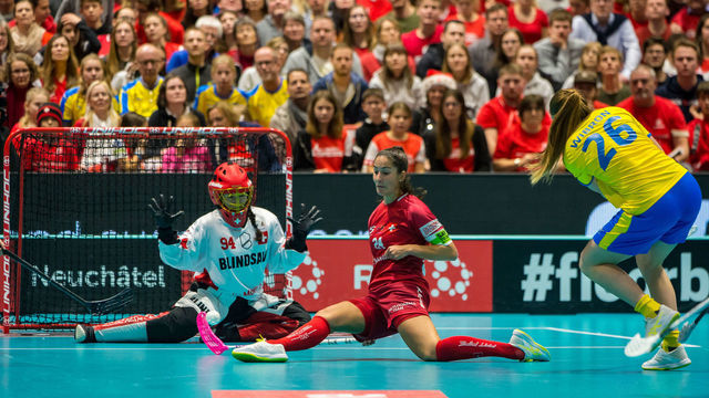 NEUCHATEL, SWITZERLAND - DECEMBER 15: #26 Wibron Emelie of Sweden tries to score against #24 Marti Flurina and #94 Heini Lara of Switzerland during the Gold Medal game of 2019 Women's World Floorball Championships between Sweden and Switzerland at Patinoires du Littoral in Neuchatel, Switzerland, on 15 December 2019.
