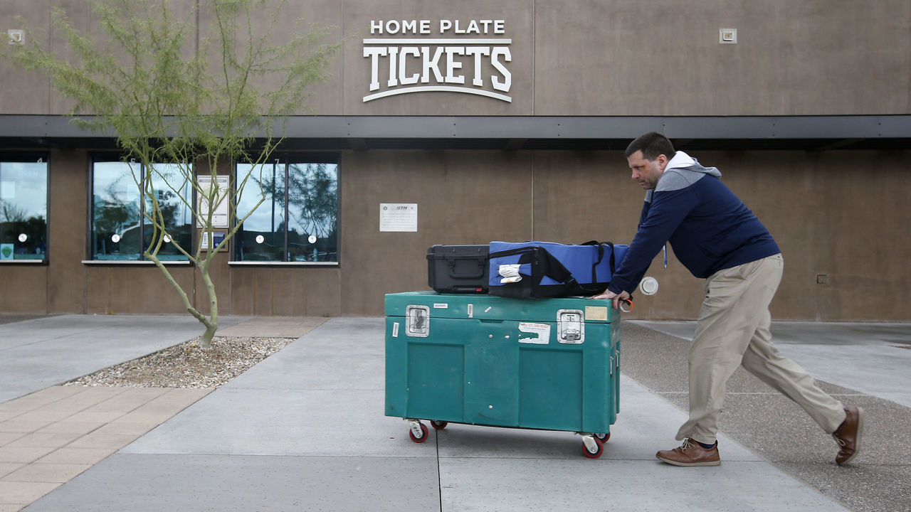 MARYVALE, - MARCH 12: Stadium personnel move equipment past the ticket windows at American Family Fields stadium, spring training home of the Milwaukee Brewers, following Major League Baseball's decision to suspend all spring training games on March 12, 2020 in Phoenix, Arizona. The decision was made due to concerns of the ongoing Coronavirus (COVID-19) outbreak.