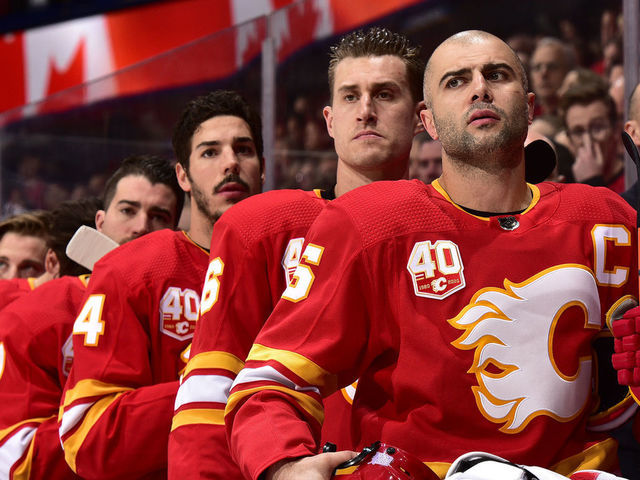 CALGARY, ALBERTA - NOVEMBER 09: Mark Giordano #5 and teammates of the Calgary Flames stand for the national anthems before the game against the St. Louis Blues at Scotiabank Saddledome on November 09, 2019 in Calgary, Canada.