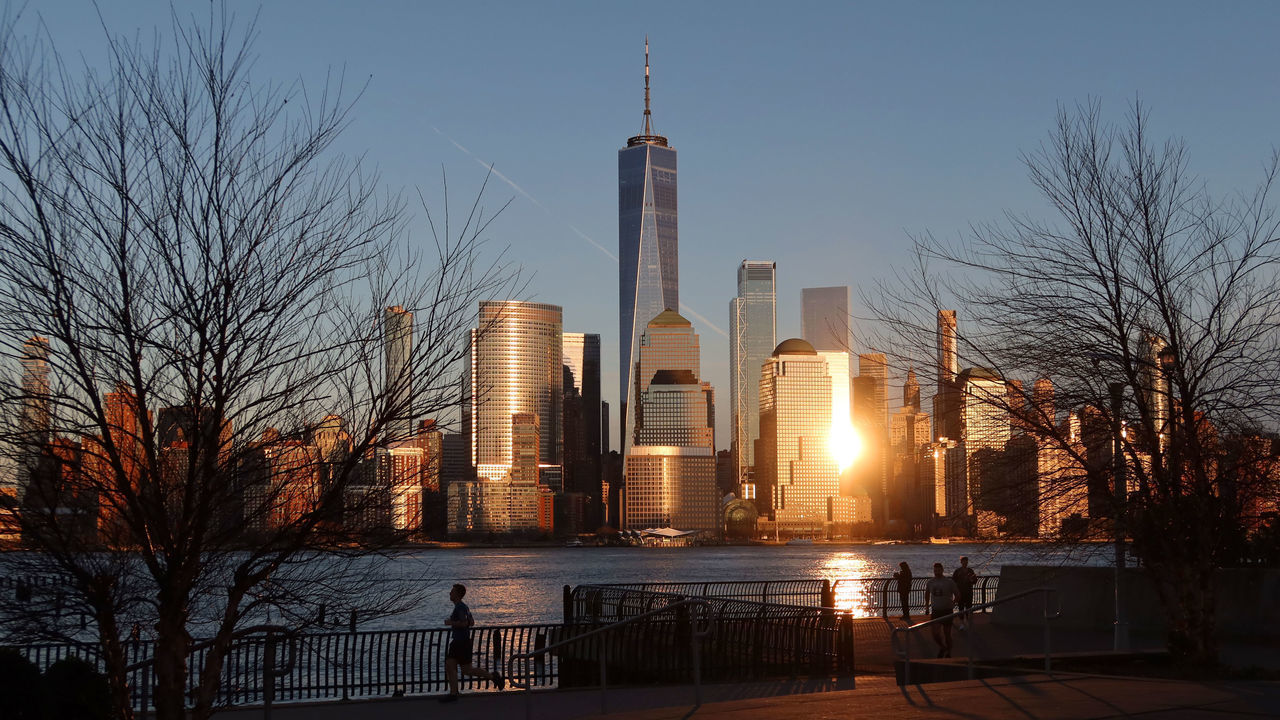 JERSEY CITY, NJ - MARCH 7: The setting sun reflects off One World Trade Center and the skyline of lower Manhattan in New York City on March 13, 2020 as seen from Jersey City, New Jersey.