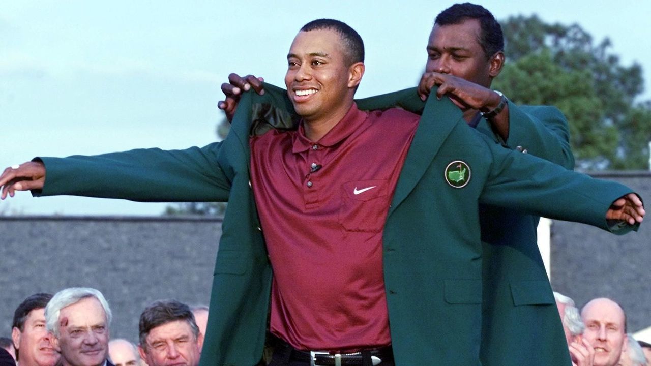 AUGUSTA, GA - APRIL 8: Tiger Woods (L) of the US gets his second green jacket from 2000 Masters Champion Vijay Singh (R) of Fiji 08 April, 2001 during the final round of the 2001 Masters Golf Tournament at the Augusta National Golf Club in Augusta, Georgia. Woods won the Masters by one stroke in Augusta 08 April to become the first golfer in history to hold all four professional Major titles at one time.