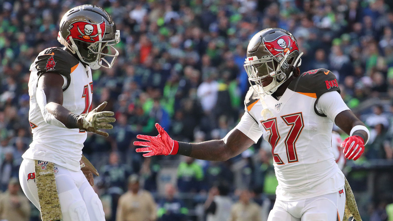 SEATTLE, WASHINGTON - NOVEMBER 03: Chris Godwin #12 (L) celebrates with Ronald Jones #27 of the Tampa Bay Buccaneers after scoring an eight yard touchdown against the Seattle Seahawks in the first quarter during their game at CenturyLink Field on November 03, 2019 in Seattle, Washington.