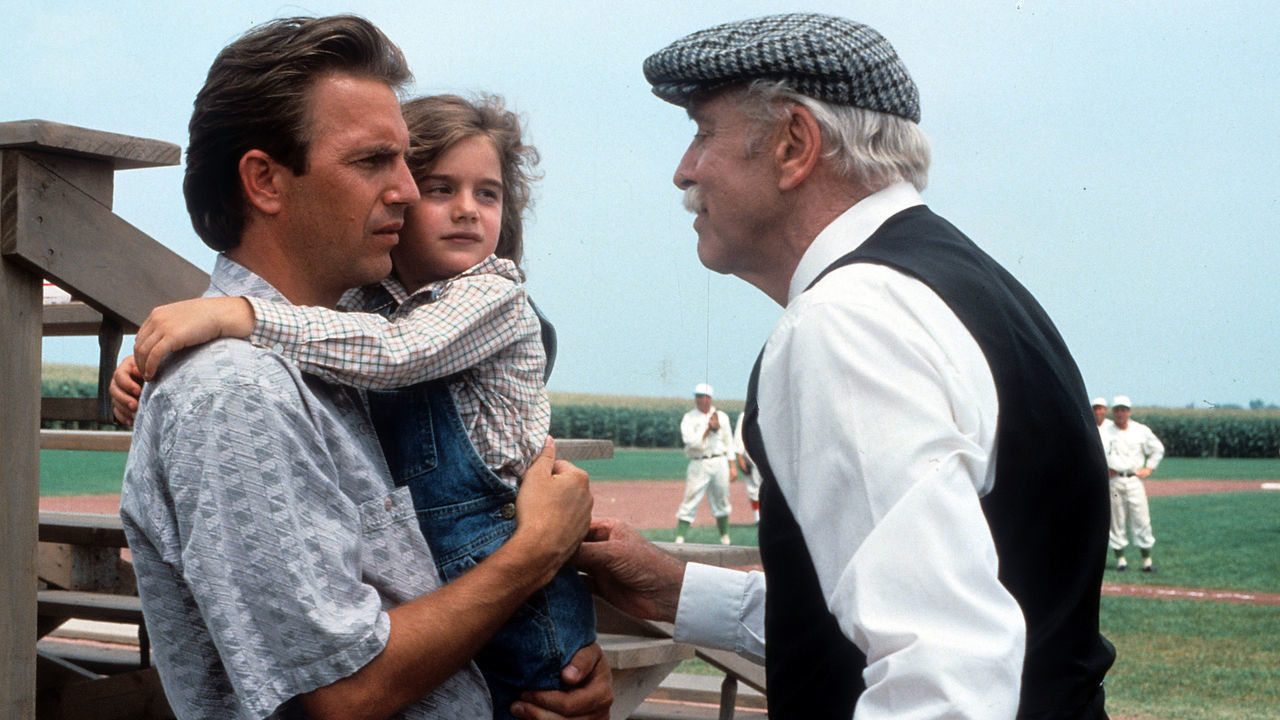 Kevin Costner holding Gaby Hoffmann in a scene from the film 'Field Of Dreams', 1989.
