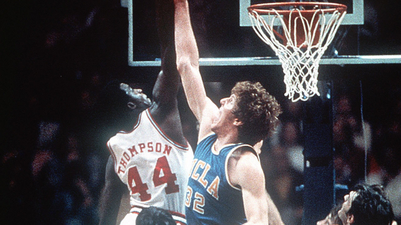23 MAR 1974: David Thompson (44) of North Carolina State skies above Bill Walton (32) of UCLA during the Men's Final Four Championship held at the Greensboro Coliseum in Greensboro, NC. North Carolina State defeated UCLA 80-77 (2 overtimes) to advance to the championship game. Rich Clarkson/NCAA Photos via Getty Images