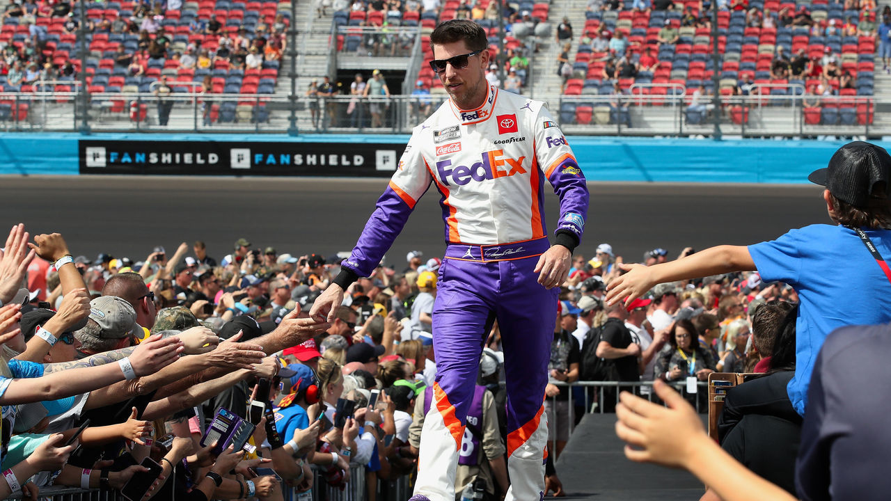 AVONDALE, ARIZONA - MARCH 08: Denny Hamlin, driver of the #11 FedEx Freight Toyota, high fives fans as he is introduced before the NASCAR Cup Series FanShield 500 at Phoenix Raceway on March 08, 2020 in Avondale, Arizona.