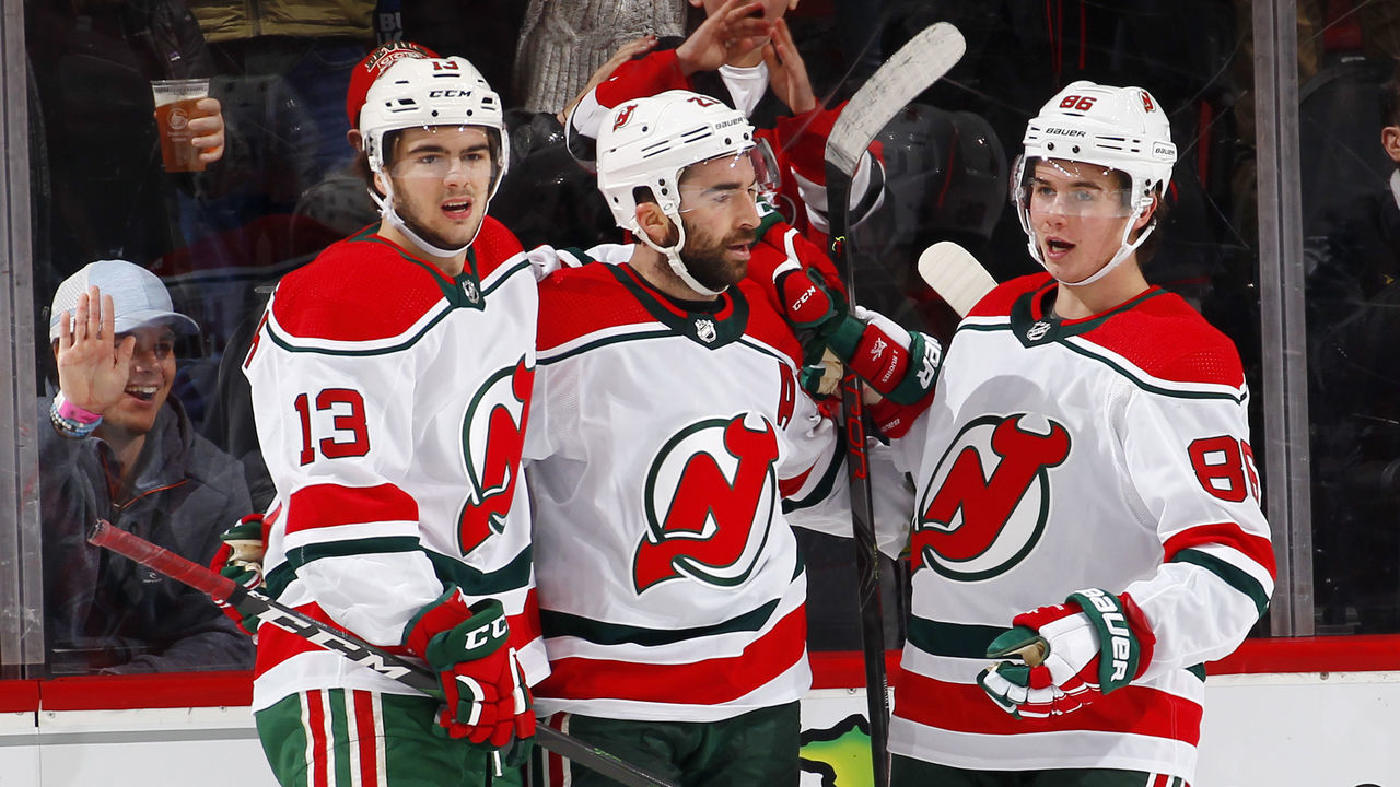 NEWARK, NJ - DECEMBER 20: Nico Hischier #13, Kyle Palmieri #21 and Jack Hughes #86 of the New Jersey Devils celebrate a goal by Palmieri during an NHL hockey game against the Washington Capitals on November 20, 2019 at the Prudential Center in Newark, New Jersey. Capitals won 6-3. Devils wore their 1980's heritage uniforms.