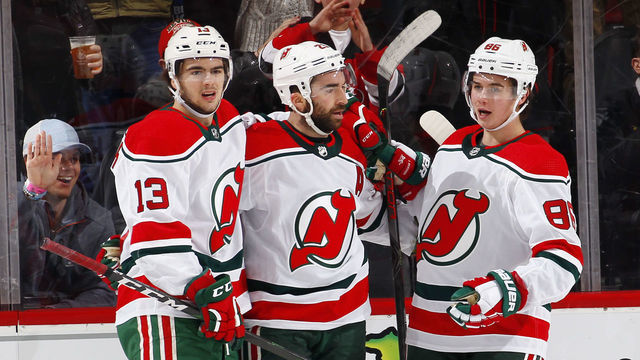 NEWARK, NJ - DECEMBER 20: Nico Hischier #13, Kyle Palmieri #21 and Jack Hughes #86 of the New Jersey Devils celebrate a goal by Palmieri during an NHL hockey game against the Washington Capitals on November 20, 2019 at the Prudential Center in Newark, New Jersey. Capitals won 6-3. Devils wore their 1980's heritage uniforms.