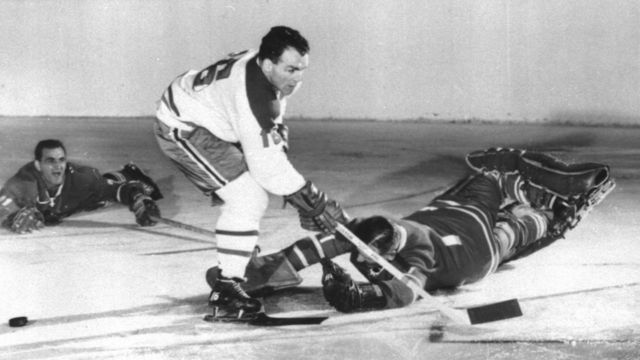 TORONTO, ON - APRIL 4: Goalie Johnny Bower #1 of the Toronto Maple Leafs makes a diving save on Henri Richard #16 of the Montreal Canadiens as Bobby Baun #21 looks on during Game 5 of the Eastern Conference Semi Finals on April 4, 1963 at the Maple Leaf Gardens in Toronto, Ontario, Canada.