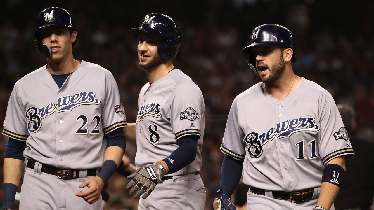 PHOENIX, ARIZONA - JULY 20: Mike Moustakas #11 of the Milwaukee Brewers celebrates with Ryan Braun #8 and Christian Yelich #22 after hitting a three-run home run against the Arizona Diamondbacks during the eighth inning of the MLB game at Chase Field on July 20, 2019 in Phoenix, Arizona.