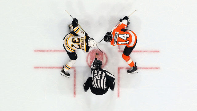 PHILADELPHIA, PA - MARCH 10: Linesman Scott Cherrey #50 prepares to drop the puck on a face-off between Sean Couturier #14 of the Philadelphia Flyers and Patrice Bergeron #37 of the Boston Bruins on March 10, 2020 at the Wells Fargo Center in Philadelphia, Pennsylvania.