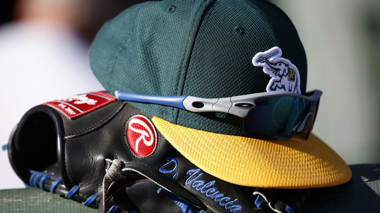 ARLINGTON, TX - SEPTEMBER 12: The cap and glove of Danny Valencia #26 of the Oakland Athletics in the team's dugout before a baseball game with the Texas Rangers at Globe Life Park in Arlington on September 12, 2015 in Arlington, Texas.