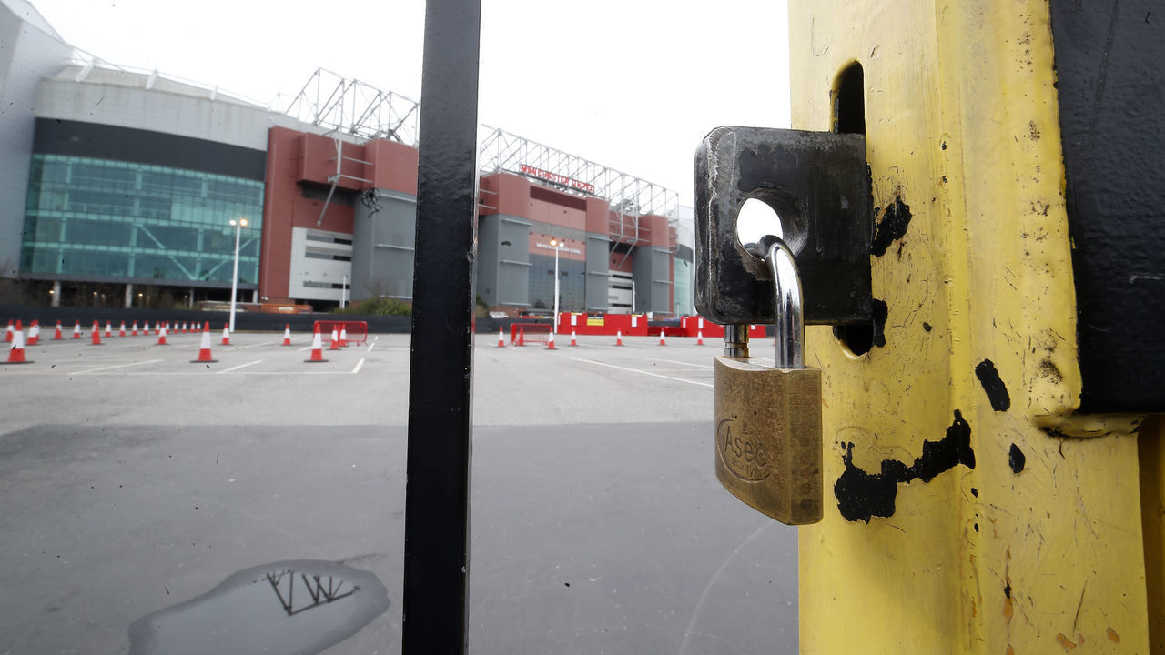 A view of locked gates at Old Trafford, home of Manchester United. Premier League clubs will gather via conference call on Thursday morning to discuss fixtures and finances amid the coronavirus pandemic.