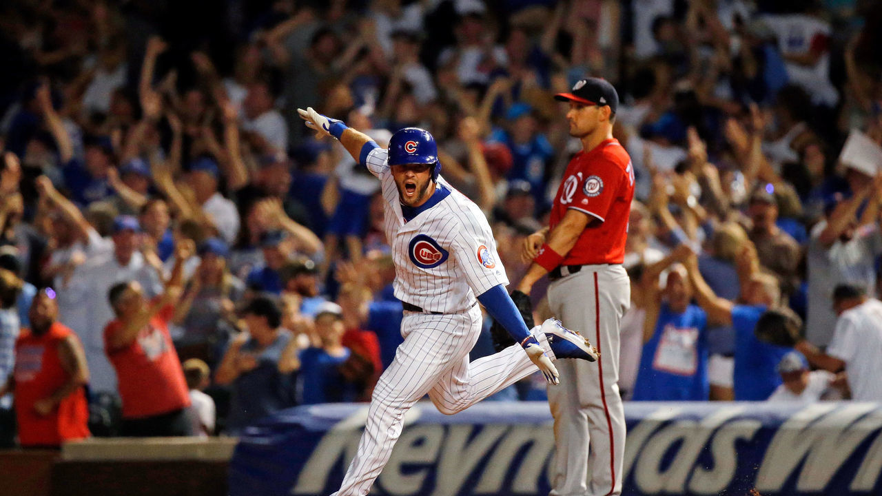 CHICAGO, IL - AUGUST 12: David Bote #13 of the Chicago Cubs celebrates his walk-off grand slam as Ryan Zimmerman #11 of the Washington Nationals looks on at Wrigley Field on August 12, 2018 in Chicago, Illinois. The Chicago Cubs won 4-3.