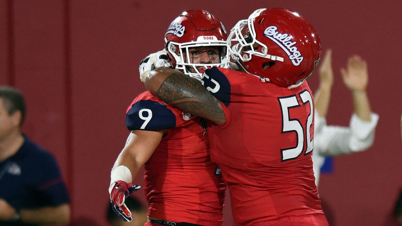 FRESNO, CA - SEPTEMBER 21: Fresno State (9) Josh Hokit (RB) celebrates with Fresno State (52) Netane Muti (OL) after running for a touchdown in the fourth quarter during a college football game between the Sacramento State Hornets and the Fresno State Bulldogs on September 21, 2019, at Bulldog Stadium in Fresno, CA.