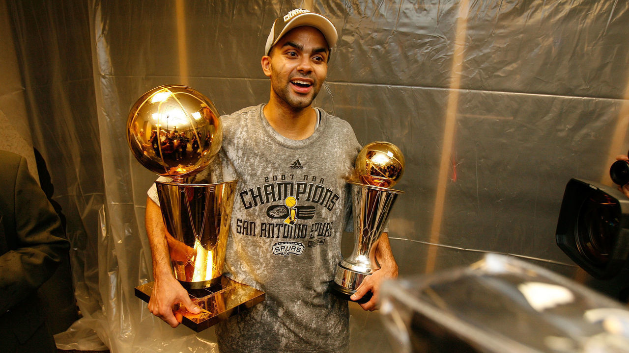 CLEVELAND - JUNE 14: Finals MVP Tony Parker #9 the San Antonio Spurs celebrates in the locker with the Larry O'Brien Championship trophy and his MVP trophy after their 83-82 win against the Cleveland Cavaliers in Game Four of the NBA Finals at the Quicken Loans Arena on June 14, 2007 in Cleveland, Ohio. NOTE TO USER: User expressly acknowledges and agrees that, by downloading and/or using this Photograph, user is consenting to the terms and conditions of the Getty Images License Agreement. Mandatory Copyright Notice: Copyright 2007 NBAE