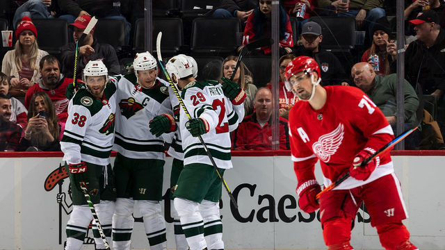 DETROIT, MI - FEBRUARY 27: Ryan Hartman #38 of the Minnesota Wild celebrates his first period goal with teammates Mikko Koivu #9 and Greg Pateryn #29 as Dylan Larkin #71 of the Detroit Red Wings skates to the bench during an NHL game at Little Caesars Arena on February 27, 2020 in Detroit, Michigan.