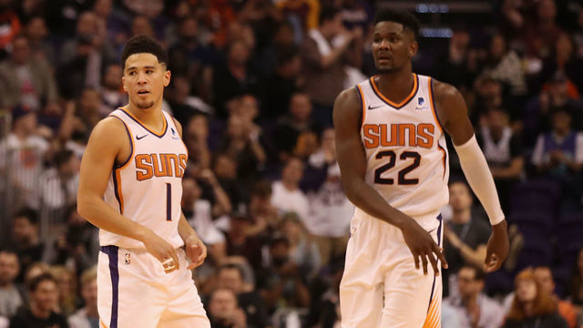 PHOENIX, AZ - OCTOBER 17: Devin Booker #1 and Deandre Ayton #22 of the Phoenix Suns during the NBA game against the Dallas Mavericks at Talking Stick Resort Arena on October 17, 2018 in Phoenix, Arizona. The Suns defeated defeated the Mavericks 121-100.