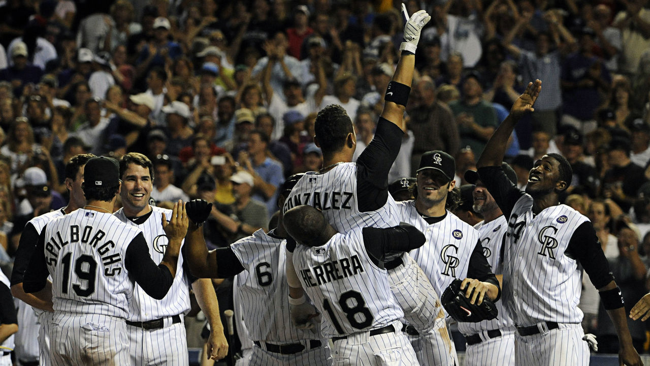 Colorado Rockies left-fielder Carlos Gonzalez is hoisted up by teammate Jonathan Herrera (18) after hitting a walk-off solo home run in the bottom of the 9th inning while hitting for the cycle. The Colorado Rockies beat the Chicago Cubs, 6-5, in Denver's Coors Field, on a hot Saturday afternoon, July 31, 2010. Diego James Robles, The Denver Post