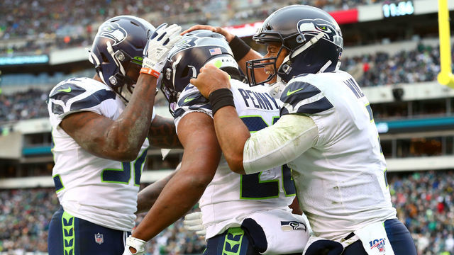 PHILADELPHIA, PENNSYLVANIA - NOVEMBER 24: Rashaad Penny #20 of the Seattle Seahawks celebrates with Russell Wilson #3 and Chris Carson #32 after rushing for a fourth quarter touchdown against the Philadelphia Eagles at Lincoln Financial Field on November 24, 2019 in Philadelphia, Pennsylvania.