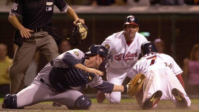 Cleveland Indians second baseman Kenny Lofton (R) scores the game-winning run ahead of the tag attempt by Seattle Mariners catcher Tom Lampkin (2nd L) as Indians DH Eddie Taubensee (2nd R) and home plate umpire Jeff Nelson (L) watch during the 11th inning, 05 August, 2001 at Jacobs Field in Cleveland, OH. Cleveland defeated Seattle 15-14 in 11 innings. AFP PHOTO/David MAXWELL