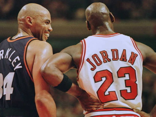 Phoenix Suns forward Charles Barkley (34) laughs at a foul call with Chicago Bulls guard Michael Jordan (23) in the first half 28 January 1996 at the United Center in Chicago. The Bulls won 93-82. Jordan scored 31 points, and Barkley scored 20 with 16 rebounds. AFP PHOTO Brian BAHR