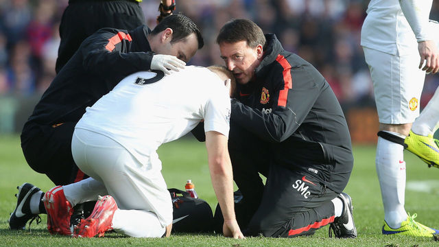 LONDON, ENGLAND - MAY 09: Luke Shaw of Manchester United receives treatment on a head injury from Doctor Steve McNally while Wayne Rooney also limps during the Barclays Premier League match between Crystal Palace and Manchester United at Selhurst Park on May 9, 2015 in London, England.