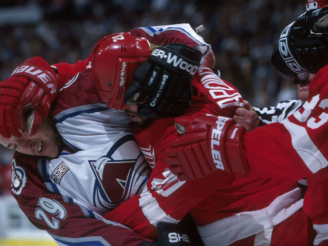 29 Apr 2000: Defenseman Eric Messier #29 of the Colorado Avalanche, left, battles right winger Martin LaPointe #20, center, and center Kris Draper #33 of the Detroit Red Wings during their Conference Semifinal game at the Pepsi Center in Denver, Colorado. Mandatory Credit: Brian Bahr/ALLSPORT