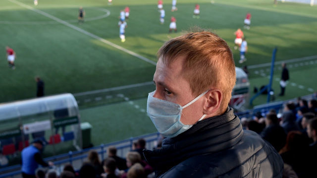 TOPSHOT - A supporter of FC Minsk, wears a facemask for protective measures amid concerns over the spread of the COVID-19, as he attends the Belarus Championship football match between FC Minsk and FC Dinamo-Minsk in Minsk, on March 28, 2020. - Belarus continue its championship despite all the leagues in Europe cancelled it to curb the spread of the COVID-19, the novel coronavirus.