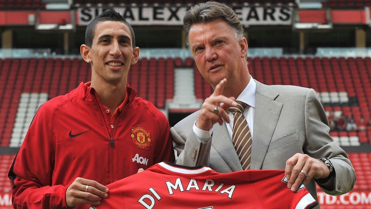 Manchester United's Dutch manager Louis van Gaal (R) poses with Manchester United's newly-signed Argentinian midfielder Angel di Maria (L) during an official presentation on the pitch at Old Trafford in Manchester, north-west England on August 28, 2014. Manchester United announced on August 26, 2014 that they have signed Argentina winger Angel di Maria from Real Madrid for a British-record transfer fee of 59.7 million GBP (98 million USD, 75 million euros). AFP PHOTO / STEVE PARKIN -- RESTRICTED TO EDITORIAL USE. No use with unauthorized audio, video, data, fixture lists, club/league logos or live services. Online in-match use limited to 45 images, no video emulation. No use in betting, games or single club/league/player publications.