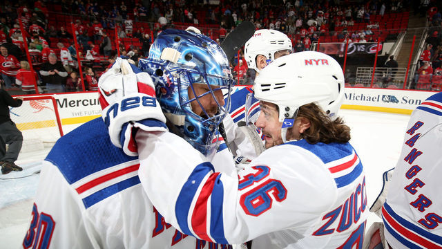 RALEIGH, NC - MARCH 31: Henrik Lundqvist #30 of the New York Rangers is congratulated for his win by teammate Mats Zuccarello #36 during an NHL game against the Carolina Hurricanes on March 31, 2018 at PNC Arena in Raleigh, North Carolina.