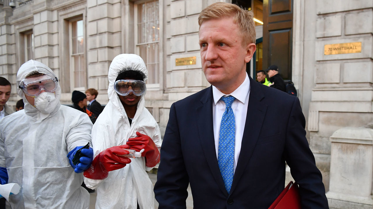 LONDON, ENGLAND - MARCH 16: Culture Secretary, Oliver Dowden leaves the Cabinet Office as youths create a tiktok video in fake hazmat suits after a COBRA meeting ahead of the first daily public updates on March 16, 2020 in London, England. Boris Johnson chaired a COBRA meeting this afternoon ahead of the first of daily televised public updates he is scheduled to give.