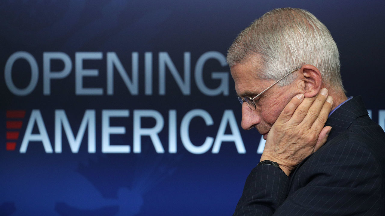 WASHINGTON, DC - APRIL 16: Dr. Anthony Fauci, director of the National Institute of Allergy and Infectious Diseases, listens to U.S. President Donald Trump speak at the daily briefing of the White House Coronavirus Task Force in the briefing room at the White House April 16, 2020 in Washington, DC. The president unveiled the administration’s plans today to ease social distancing requirements after an earlier call with the nation’s governors.