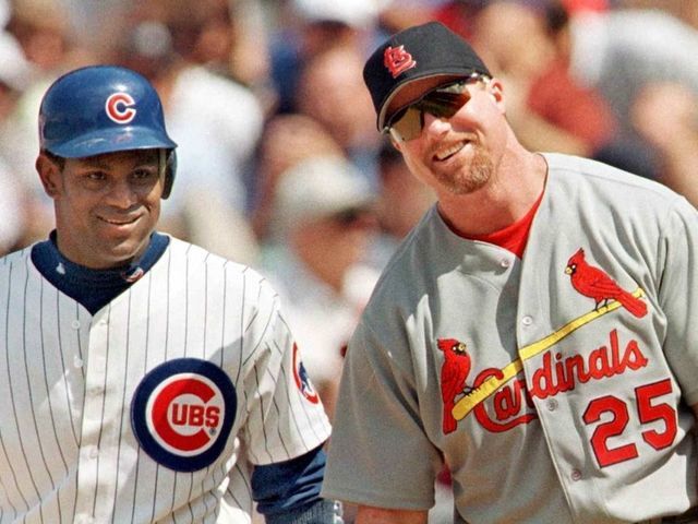 CHICAGO, UNITED STATES: The Chicago Cubs' Sammy Sosa stands with St. Louis Cardinal's first baseman Mark McGwire between pitches after Sosa singled in the second inning 28 May, 1999, at Wrigley Field in Chicago, Illinois. It was the first time the pair had played each other since last year's home run race. The Cubs won 6-3 with help from a home run from Sosa. AFP PHOTO/John ZICH