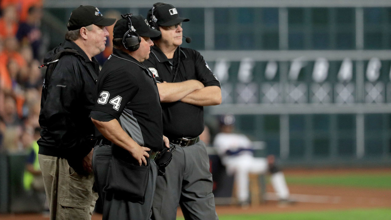 HOUSTON, TEXAS - OCTOBER 29: Umpires Sam Holbrook #34 and Gary Cederstrom #38 discuss the runner interference call on Trea Turner (not pictured) of the Washington Nationals on headset during the seventh inning in Game Six of the 2019 World Series between the Houston Astros and the Washington Nationals at Minute Maid Park on October 29, 2019 in Houston, Texas.