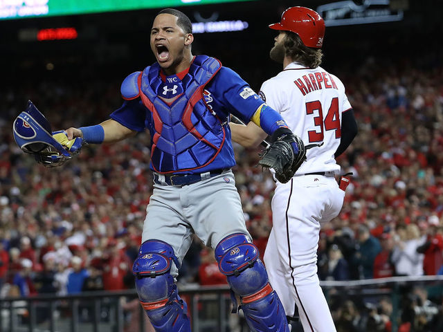 WASHINGTON, DC - OCTOBER 13: Willson Contreras #40 of the Chicago Cubs celebrates next to Bryce Harper #34 of the Washington Nationals after Harper struck out to end Game 5 of the National League Divisional Series at Nationals Park on October 13, 2017 in Washington, DC. The Cubs won the game 9-8 and will advance to the National League Championship Series against the Los Angeles Dodgers.