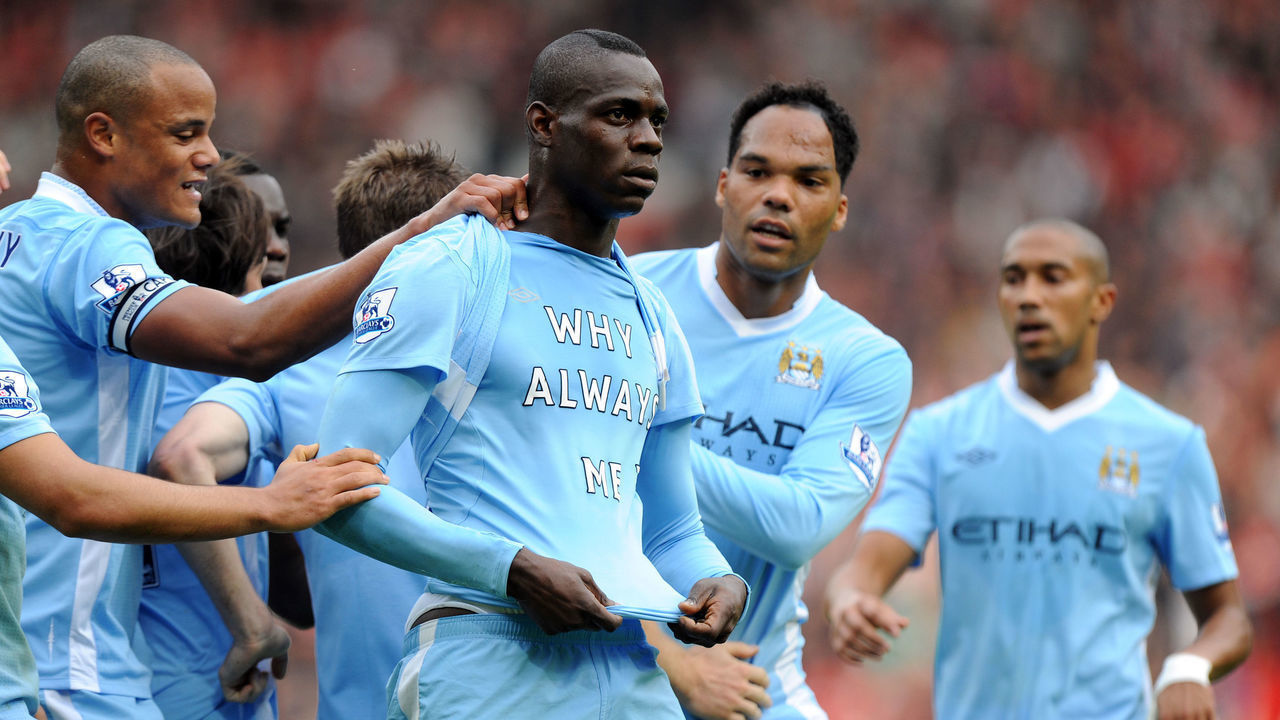 Mario Balotelli of Manchester City celebrates after scoring a goal to make it 0-1 Showing off a shirt saying "Why Always Me?"