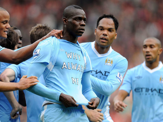 Mario Balotelli of Manchester City celebrates after scoring a goal to make it 0-1 Showing off a shirt saying "Why Always Me?"