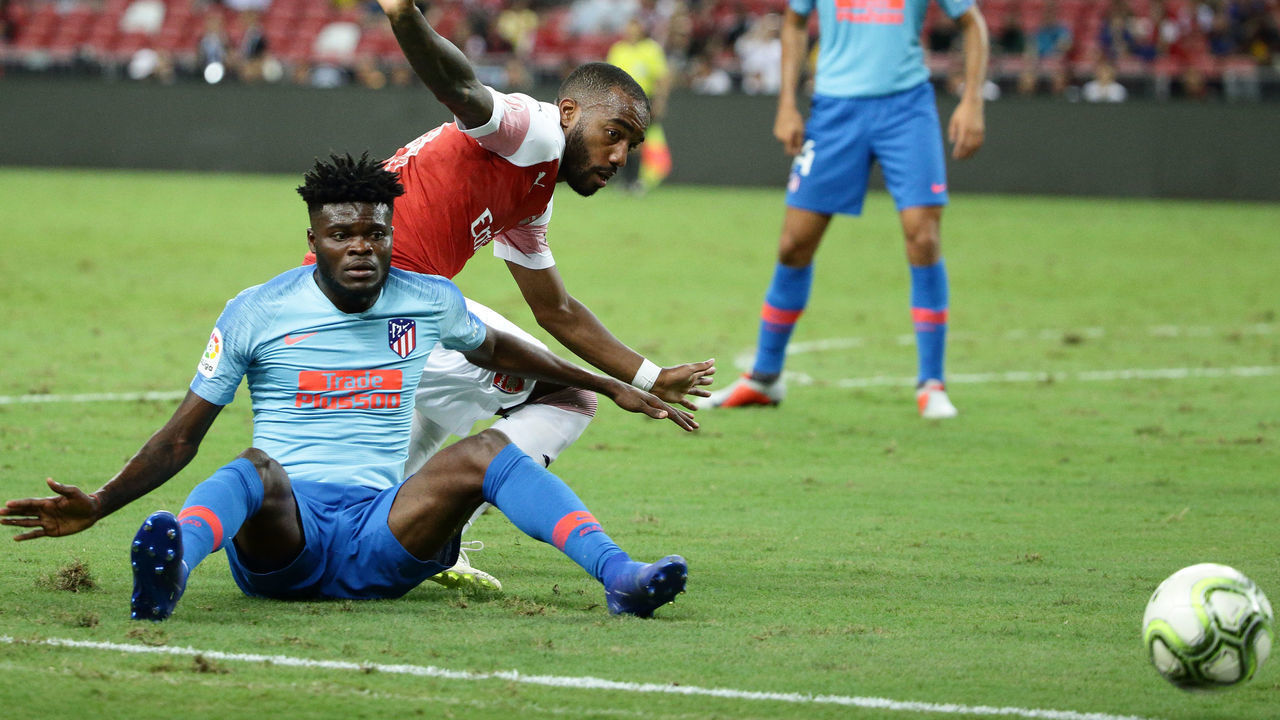 SINGAPORE - JULY 26: Thomas Partey of Atletico Madrid and Alexandre Lacazette of Arsenal challenge for the ball during the International Champions Cup 2018 match between Atletico Madrid and Arsenal at the National Stadium on July 26, 2018 in Singapore.