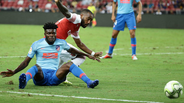 SINGAPORE - JULY 26: Thomas Partey of Atletico Madrid and Alexandre Lacazette of Arsenal challenge for the ball during the International Champions Cup 2018 match between Atletico Madrid and Arsenal at the National Stadium on July 26, 2018 in Singapore.