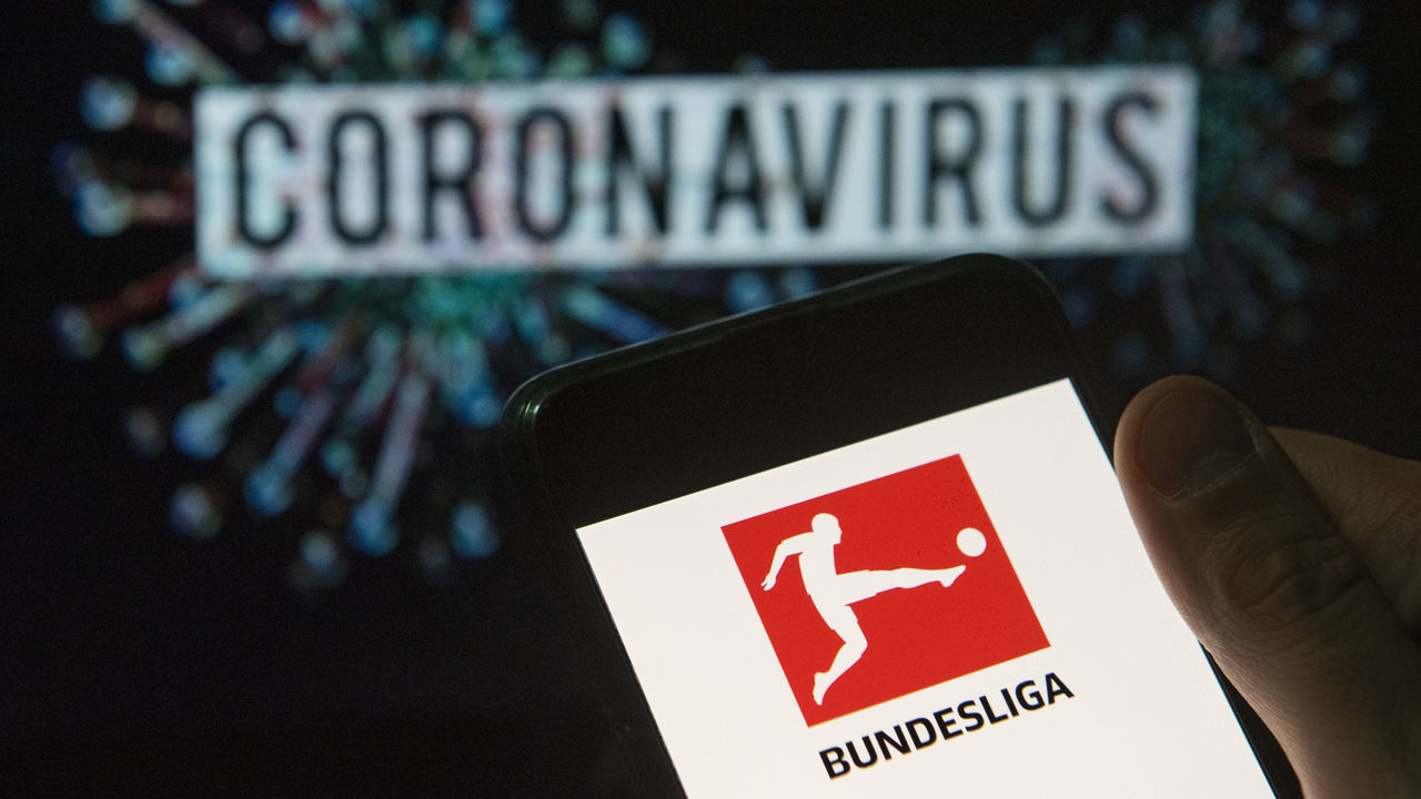 CHINA - 2020/03/24: In this photo illustration the German professional association football league Bundesliga logo seen displayed on a smartphone with a computer model of the COVID-19 coronavirus on the background. (Photo Illustration by Budrul Chukrut/SOPA Images/LightRocket via Getty Images)