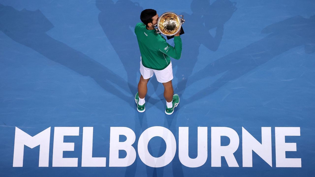 Serbia's Novak Djokovic kisses the Norman Brooks Challenge Cup trophy after winning against Austria's Dominic Thiem in their men's singles final match on day fourteen of the Australian Open tennis tournament in Melbourne on February 3, 2020.