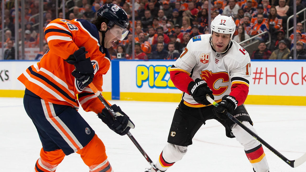 EDMONTON, AB - JANUARY 29: James Neal #18 and Connor McDavid #97 of the Edmonton Oilers try to cover Milan Lucic #17 of the Calgary Flames during the second period at Rogers Place on January 29, 2020, in Edmonton, Canada.