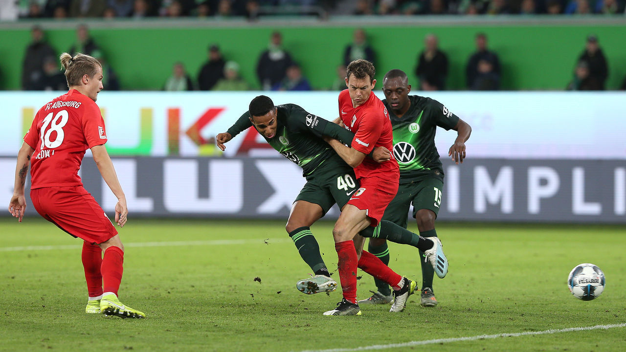 WOLFSBURG, GERMANY - OCTOBER 27: Joao Victor (L) and Jerome Roussillon (R) of VfL Wolfsburg and Stephan Lichtsteiner (C) of FC Augsburg battle for the ball during the Bundesliga match between VfL Wolfsburg and FC Augsburg at Volkswagen Arena on October 27, 2019 in Wolfsburg, Germany.