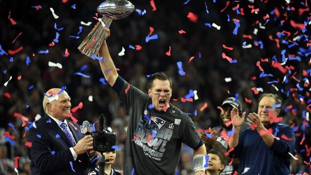 TOPSHOT - Tom Brady #12 of the New England Patriots holds the Vince Lombardi Trophy as Head coach Bill Belichick (R) looks on after defeating the Atlanta Falcons 34-28 in overtime during Super Bowl 51 at NRG Stadium on February 5, 2017 in Houston, Texas. The Patriots defeated the Falcons 34-28 after overtime. / AFP PHOTO / Timothy A. CLARY